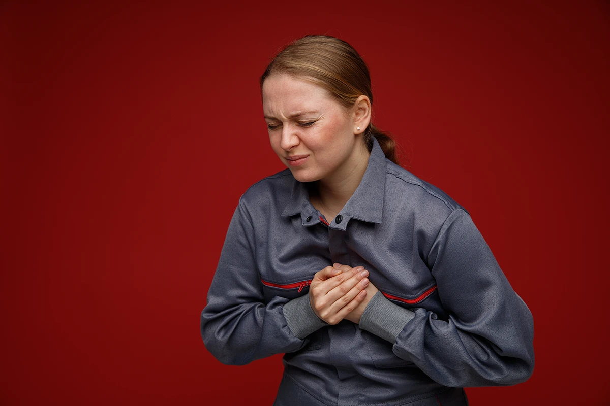 Person experiencing heartburn discomfort with a burning sensation in the chest and upper stomach area.